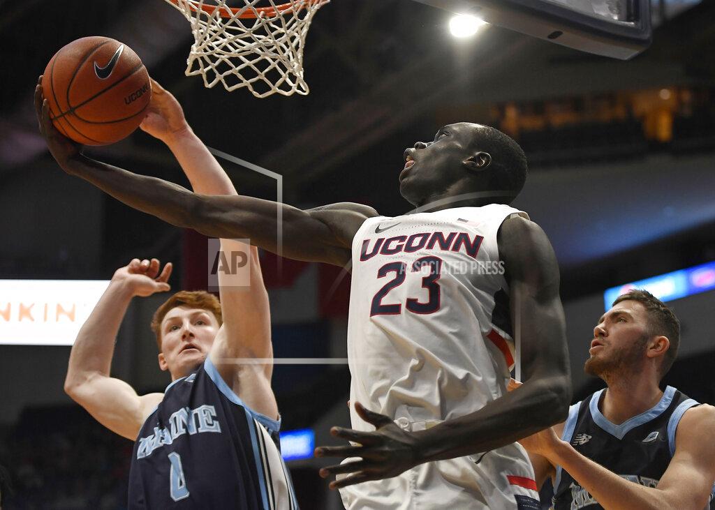 Jessica Hill Maine's Andrew Fleming, left, blocks a shot-attempt by Connecticut's Akok Akok as Maine's Nedeljko Prijovic, right, defends, during the first half of an NCAA college basketball game, Sunday, Dec. 1, 2019, in Hartford, Conn. (AP Photo/Jessica Hill)