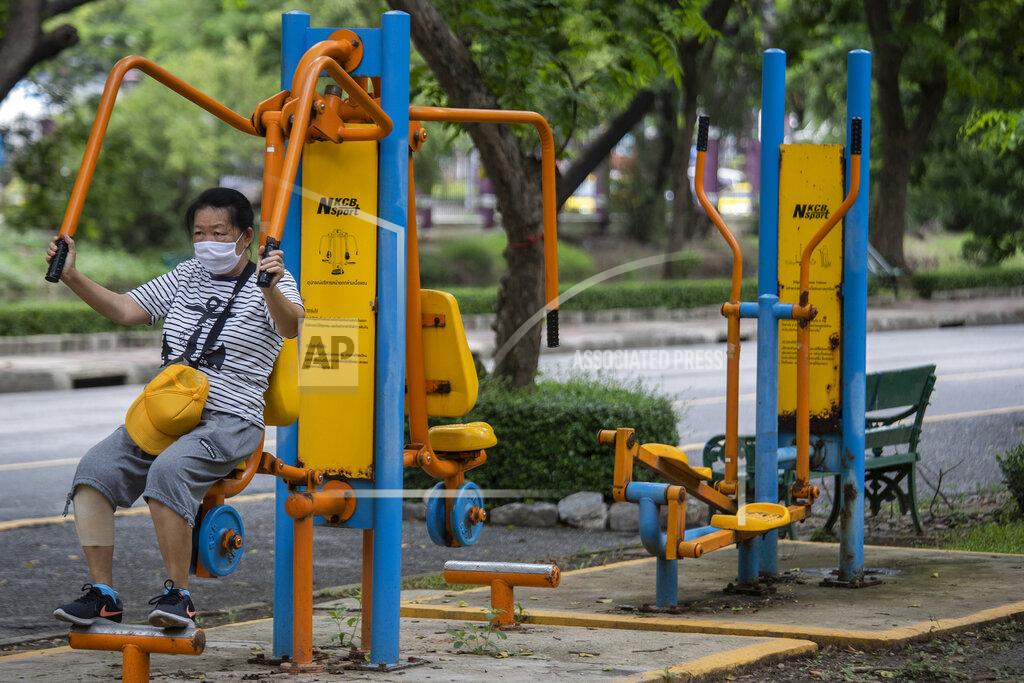 Sakchai Lalit A woman wearing a face mask to help curb the spread of the new coronavirus exercises at Lumpini park in Bangkok, Thailand, Friday, June 26, 2020. Daily life in the capital resumes to normal as the government continues to ease restrictions related to running business and activities that were imposed weeks ago to combat the spread of COVID-19. Thailand reported no local transmissions of the coronavirus in the past 4 weeks. (AP Photo/Sakchai Lalit)