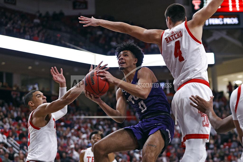 Brad Tollefson TCU's Micah Peavy (0) shoots around Texas Tech's Kevin McCullar, left, and Daniel Batcho (4) during the first half of an NCAA college basketball game on Saturday, Feb. 12, 2022, in Lubbock, Texas. (AP Photo/Brad Tollefson)