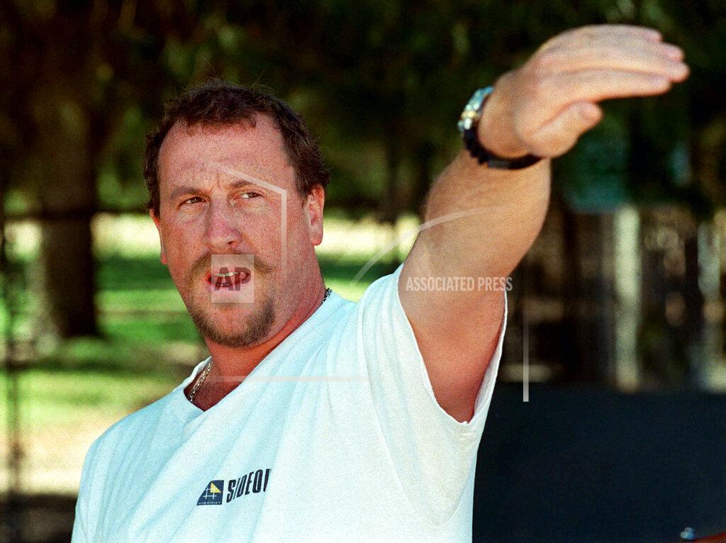 E.J. Flynn FILE - In this April 26, 1997, file photo, George Holliday points to the spot along a roadside in the Lake View Terrace section of Los Angeles where he videotaped Rodney King being beaten in April 1992, during a news conference in Los Angeles. Holliday, a plumber who gained local and national fame 30 years earlier when he used his video camera to tape the infamous Los Angeles police beating of motorist Rodney King in Lake View Terrace, has died from COVID-19, it was reported Monday, Sept. 20, 2021. (AP Photo/E.J. Flynn, File)