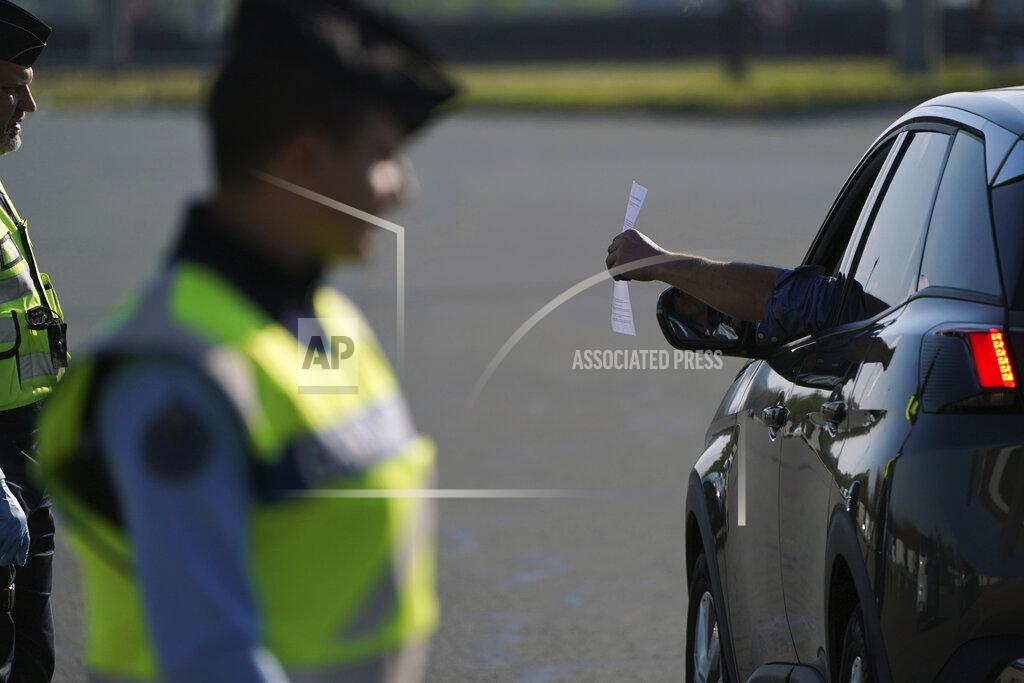 Laurent Cipriani Police officers check documents to ensure nationwide confinement measures due to coronavirus are upheld, at a highway toll gate in Villefranche our Saone, north of Lyon, central France, Friday, April 3, 2020. Friday marks the first day of springtime school holidays for a large part of France including Paris, when under normal circumstances cars would clog highways as families head on vacation around the country. The new coronavirus causes mild or moderate symptoms for most people, but for some, especially older adults and people with existing health problems, it can cause more severe illness or death. (AP Photo/Laurent Cipriani)