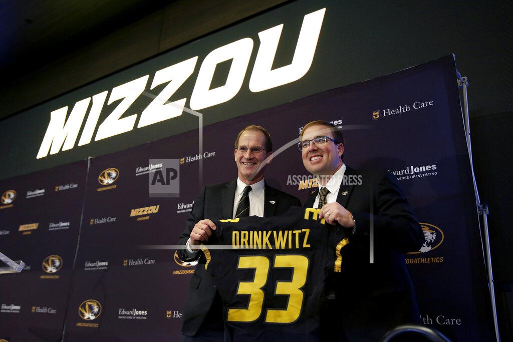 Jeff Roberson University of Missouri Director of Athletics Jim Sterk, left, holds up a jersey with Eliah Drinkwitz after introducing Drinkwitz as the new NCAA college football head coach at the school, Tuesday, Dec. 10, 2019, in Columbia, Mo. Drinkwitz becomes the 33rd head football coach at Missouri after coaching the 2019 season at Appalachian State. (AP Photo/Jeff Roberson)