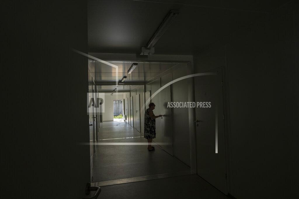 Nariman El-Mofty An elderly woman opens the door to her room in a trailer set up for temporary housing for people who lost their homes destroyed from Russian aerial bombs, in Borodyanka, Kyiv region, Ukraine, Tuesday, June 28, 2022. Trailers like this have become a popular way to offer a home to people who can't return to their own. In Borodyanka's camp live 257 people, 35% of them elderly residents. (AP Photo/Nariman El-Mofty)