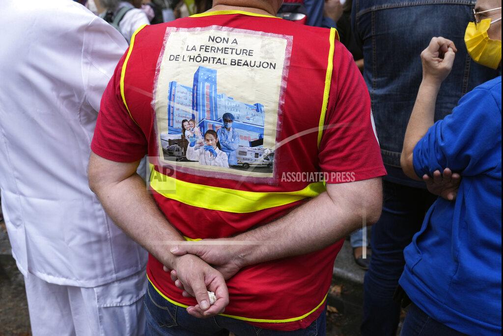Francois Mori A medical worker holds a placard reading : "No at closing of the Beaujon Hospital", during a protest gathering outside the Health Ministry, in Paris, Tuesday, Sept. 14, 2021 against a law requiring them to get vaccinated by Wednesday or risk suspension from their jobs. The law is aimed at protecting patients from new surges of COVID-19. Most of the French population is vaccinated but a vocal minority are against the vaccine mandate. (AP Photo/Francois Mori)