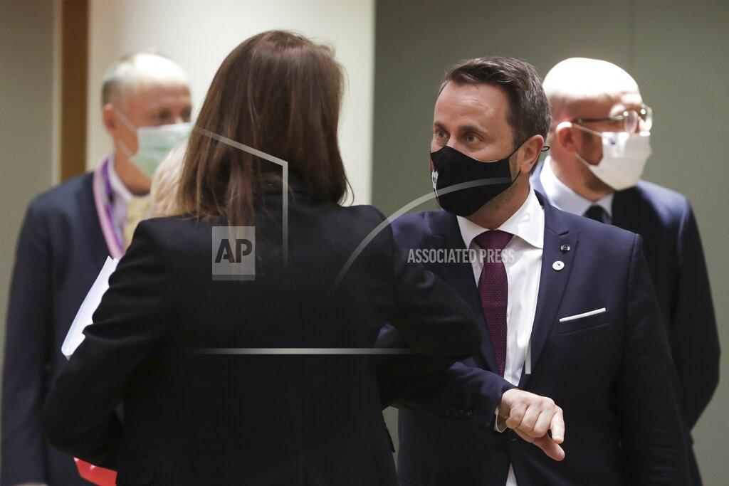 Stephanie Lecocq Luxembourg's Prime Minister Xavier Bettel, center, greets Belgium's Prime Minister Sophie Wilmes with an elbow bump during a round table meeting at an EU summit in Brussels, Friday, July 17, 2020. Leaders from 27 European Union nations meet face-to-face on Friday for the first time since February, despite the dangers of the coronavirus pandemic, to assess an overall budget and recovery package spread over seven years estimated at some 1.75 trillion to 1.85 trillion euros. (Stephanie Lecocq, Pool Photo via AP)
