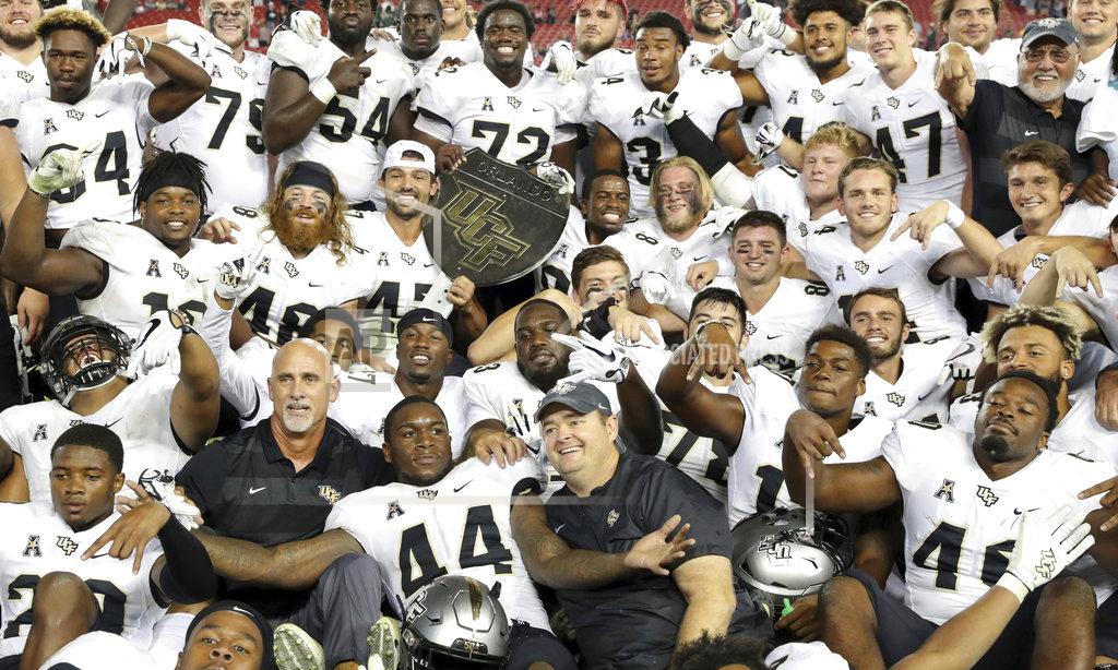 Mike Carlson Central Florida celebrates with the War on I-4 trophy after defeating South Florida in an NCAA college football game Friday, Nov. 23, 2018, in Tampa, Fla. (AP Photo/Mike Carlson)
