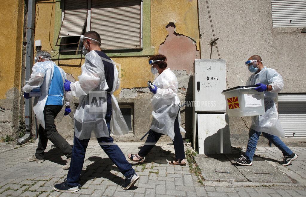 Boris Grdanoski Members of a special election team with a ballot box and voting material make their way visiting voters who have tested positive for COVID-19 or are in self-isolation, in Skopje, North Macedonia, Monday, July 13, 2020. North Macedonia holds its first parliamentary election under its new country name this week, with voters heading to the polls during an alarming spike of coronavirus cases in the small Balkan nation. Opinion polls in the run-up to Wednesday’s vote indicate a close race between coalitions led by the Social Democrats and the center-right opposition VMRO-DPMNE party. (AP Photo/Boris Grdanoski)