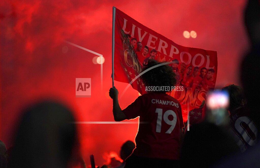 Jon Super Liverpool supporters celebrate as they gather outside of Anfield Stadium in Liverpool, England, Thursday, June 25, 2020 after Liverpool clinched the English Premier League title. Liverpool took the title after Manchester City failed to beat Chelsea on Wednesday evening. (AP photo/Jon Super)