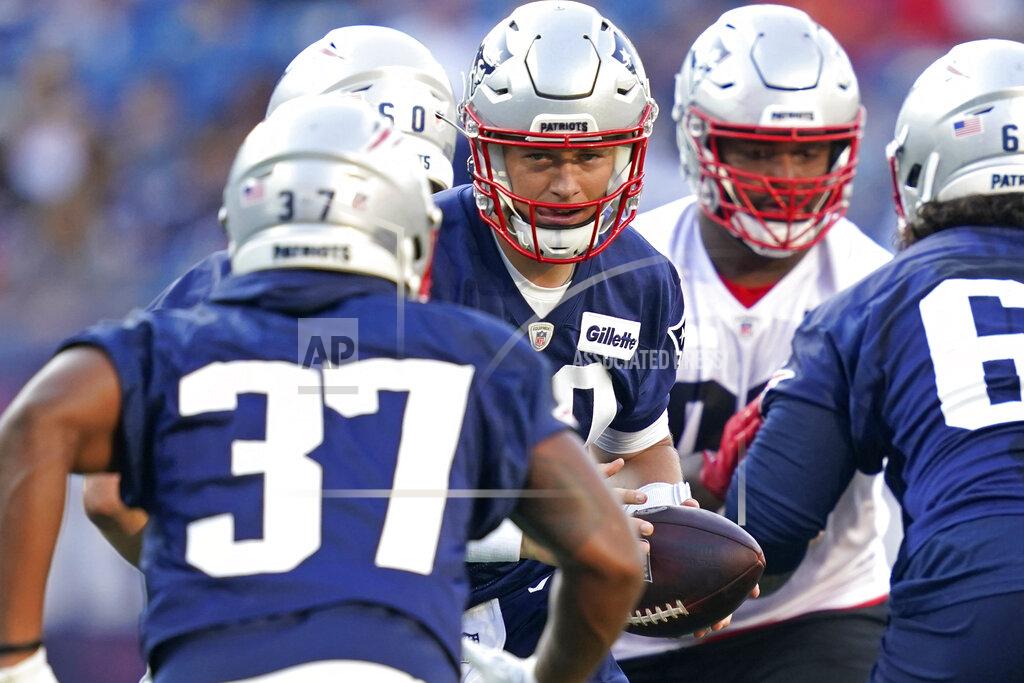 Elise Amendola New England Patriots quarterback Mac Jones, center, hands off the ball during an NFL football practice at Gillette Stadium, Friday, Aug. 6, 2021, in Foxborough, Mass. (AP Photo/Elise Amendola)