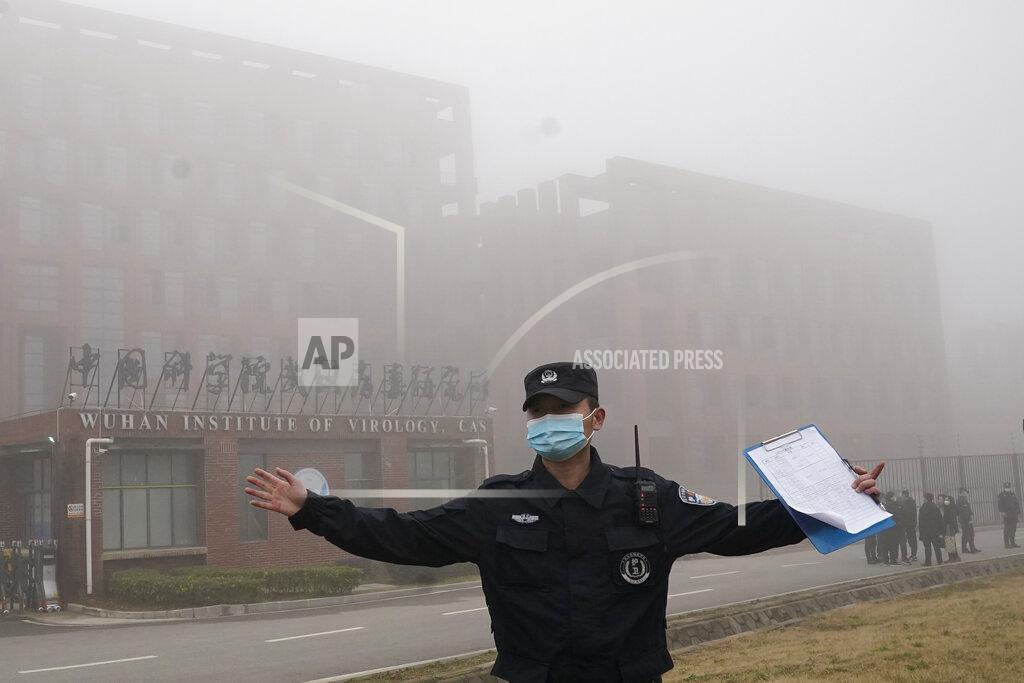 Ng Han Guan A security person moves journalists away from the Wuhan Institute of Virology after a World Health Organization team arrived for a field visit in Wuhan in China's Hubei province Wednesday, Feb. 3, 2021. The WHO team is investigating the origins of the coronavirus pandemic has visited two disease control centers in the province. (AP Photo/Ng Han Guan)