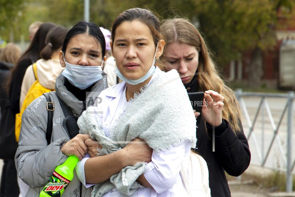 Anastasia Yakovleva Students look on, near the Perm State University in Perm, about 1,100 kilometers (700 miles) east of Moscow, Russia, Monday, Sept. 20, 2021. A gunman opened fire in a university in the Russian city of Perm on Monday morning, leaving at least eight people dead and others wounded, according to Russia's Investigative Committee. (AP Photo/Anastasia Yakovleva)