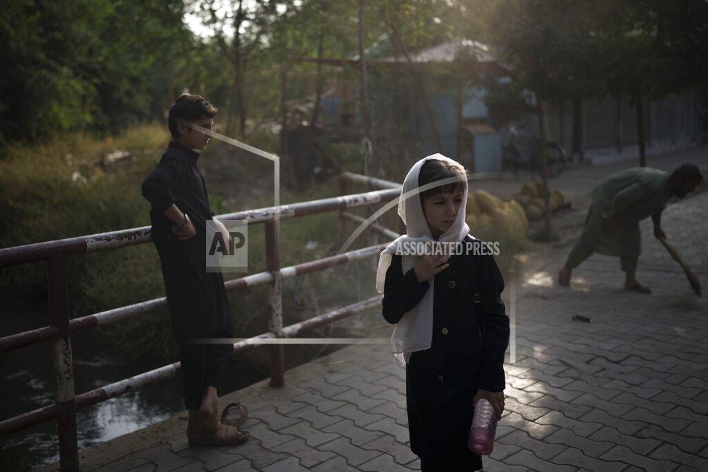 Felipe Dana A girl waits for her friends as they walk to school in Kabul, Afghanistan, Sunday, Sept. 12, 2021. (AP Photo/Felipe Dana)