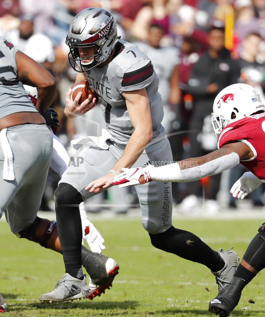 Rogelio V. Solis Mississippi State quarterback Nick Fitzgerald (7) scrambles past the outstretched arms of an Arkansas defender during the second half of an NCAA college football game in Starkville, Miss., Saturday, Nov. 17, 2018. Mississippi State won 52-6. (AP Photo/Rogelio V. Solis)