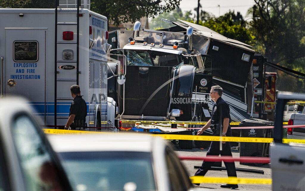Damian Dovarganes FILE - In this July 1, 2021 file photo police officers walk past the remains of an armored Los Angeles Police Department tractor-trailer, after illegal fireworks seized at a home exploded, in South Los Angeles. Arturo Ceja III, the man who stockpiled illegal fireworks in his South Los Angeles backyard — which were later improperly detonated by police, likely causing the massive blast in late June that rocked a neighborhood and injured 17 people — now faces a decade in federal prison. Ceja pleaded guilty Monday, Aug. 30 to one count of transportation of explosives without a license. (AP Photo/Damian Dovarganes, File)