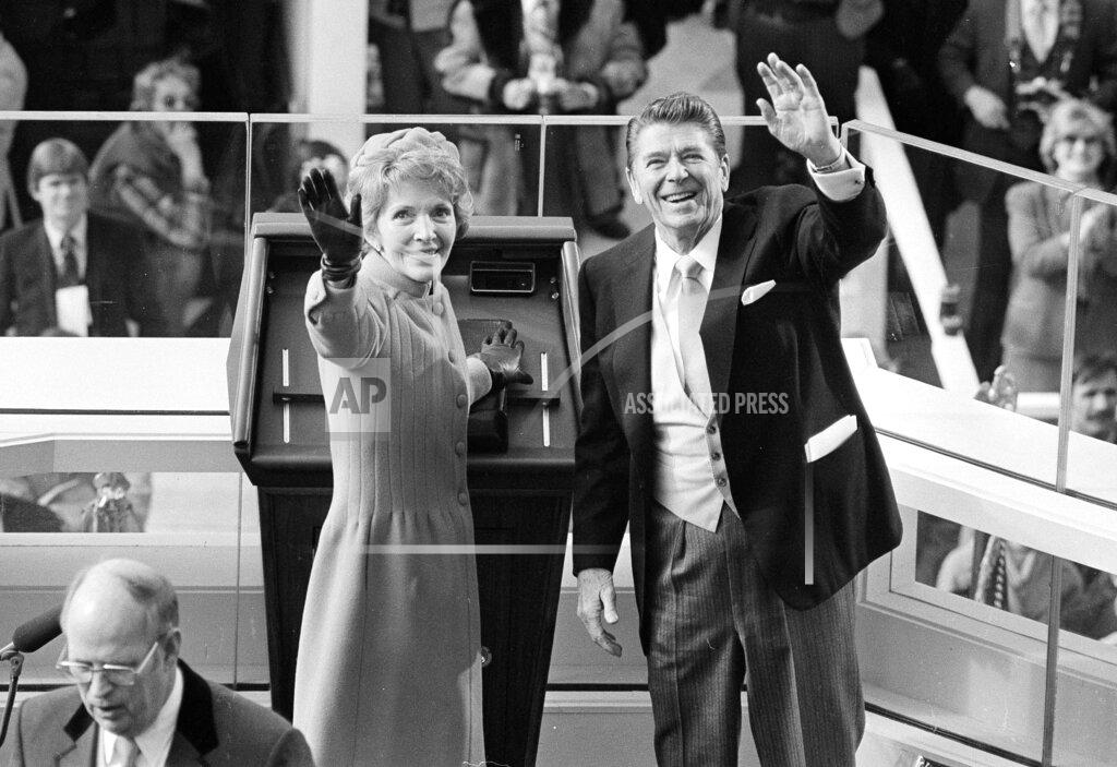 Anonymous FILE - In this Jan. 20, 1981, file photo, President Ronald Reagan and first lady Nancy Reagan wave to onlookers at the Capitol building as they stand at the podium in Washington following the swearing in ceremony. (AP Photo/File)
