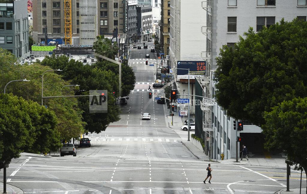 Chris Pizzello A jogger crosses a deserted 4th Street as stay-at-home orders continue in California due to the coronavirus, Friday, April 10, 2020, in downtown Los Angeles. (AP Photo/Chris Pizzello)