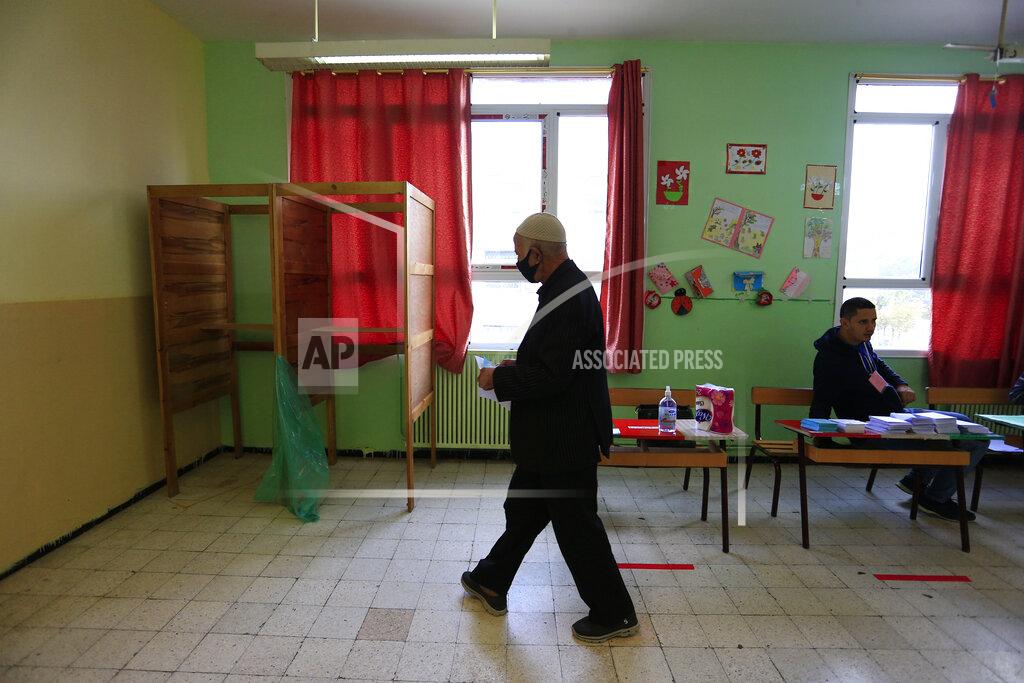 Toukik Doudou A man prepares to vote at a polling station during a vote for a revised constitution, in Algiers, Sunday, Nov. 1, 2020. Algerians are voting on whether to approve a revised constitution that imposes term limits and aims at answering demands from pro-democracy protesters who pushed out the president last year. (AP Photo/Toufik Doudou)