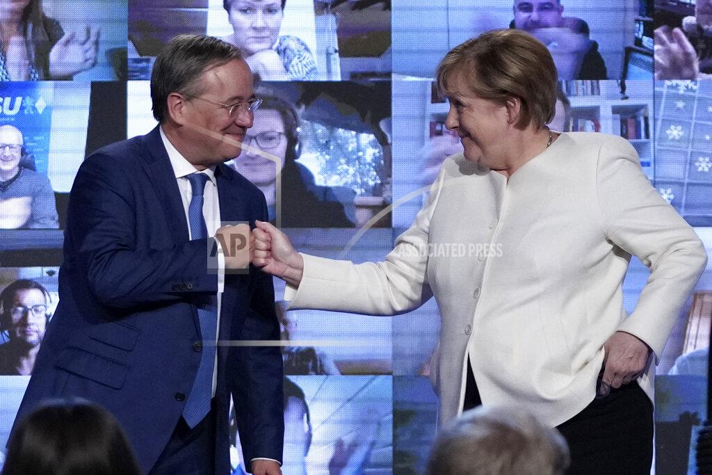 Matthias Schrader German chancellor Angela Merkel, right, and Christian Democrats candidate Armin Laschet shake hands after a state election campaign in Munich, Germany, Friday, Sept. 24, 2021 two days before the General election on Sunday, Sept. 26, 2021. (AP Photo/Matthias Schrader)