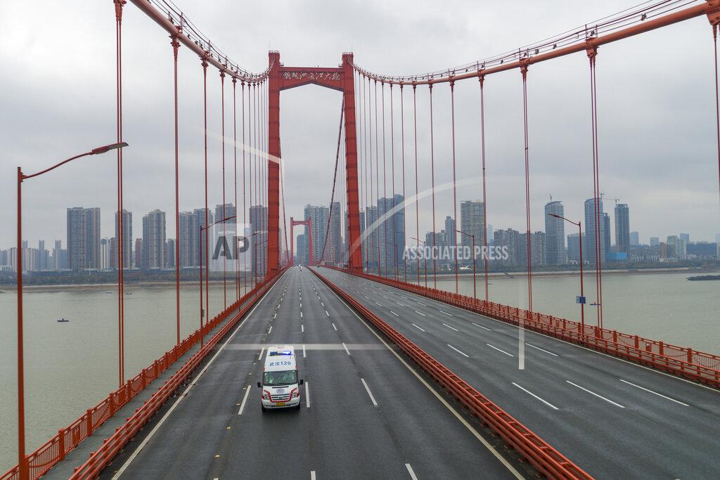 Uncredited FILE - In this Jan. 25, 2020, file photo, an ambulance drives across a nearly empty bridge in Wuhan in central China's Hubei Province. The Chinese city of Wuhan is looking back on a year since it was placed under a 76-day lockdown beginning Jan. 23, 2020. (Chinatopix via AP, File)