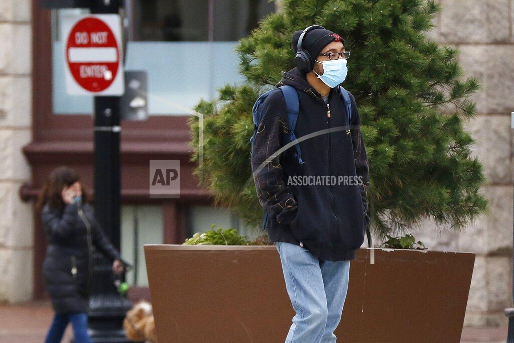 A man wears a protective mask as he walks along the Greenway during the coronavirus pandemic, Tuesday, April 21, 2020, in downtown Boston. (AP Photo/Bill Sikes)