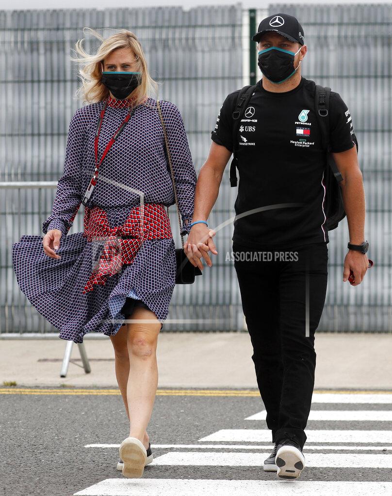 Frank Augstein Mercedes driver Valtteri Bottas of Finland, right, and his girlfriend Tiffany Cromwell arrive at the paddocks for preparations before the 70th Anniversary Formula One Grand Prix at the Silverstone circuit, Silverstone, England, Thursday, Aug. 6, 2020.(AP Photo/Frank Augstein)