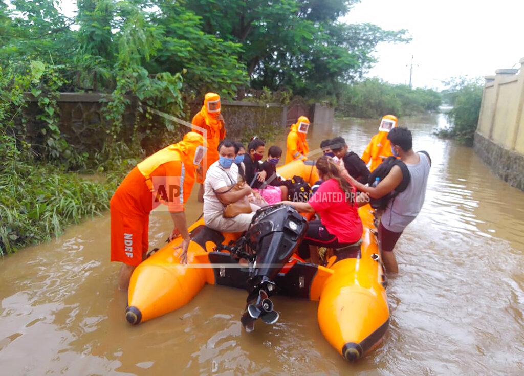 Uncredited This photograph provided by India's National Disaster Response Force (NDRF) shows NDRF personnel rescuing people stranded in floodwaters in Bhiwandi, in the western Indian state of Maharashtra, Thursday, July 22, 2021. Landslides triggered by heavy monsoon rains hit parts of western India, killing at least five people and leading to the overnight rescue of more than 1,000 other people trapped by floodwaters, an official said Friday. (National Disaster Response Force via AP)