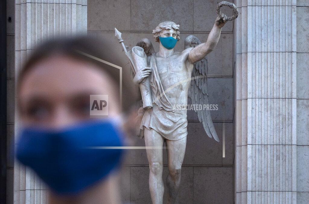 Dmitri Lovetsky A woman wearing a face mask to protect against coronavirus infection walks past a statue with a face mask at a mall in St. Petersburg, Russia, Monday, Sept. 14, 2020. Russia has seen an increase in new cases of coronavirus in recent weeks and hospitalizations have started to increase. (AP Photo/Dmitri Lovetsky)