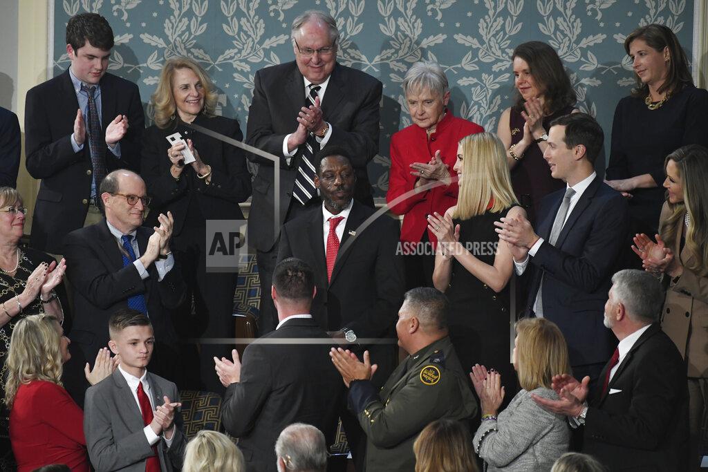 In this Feb. 4, 2020, photo, Tony Rankins, center in red tie, receives a standing ovation during the State of the Union address to a joint session of Congress on Capitol Hill in Washington. Rankins, a formerly homeless, drug-addicted Army vet, got the standing ovation after President Donald Trump described how he turned his life around thanks to a construction job at a company using the administration’s “Opportunity Zone” tax breaks targeting poor neighborhoods. Rankins, a tradesman who has indeed moved out of his car and into an apartment since landing the job refurbishing a Nashville hotel two years ago, doesn’t work at a site using the tax breaks and never has. (AP Photo/Susan Walsh)