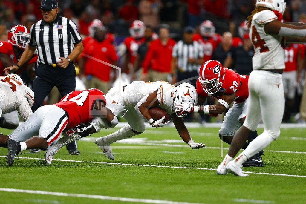 Butch Dill Texas running back Tre Watson (5) is stopped by Georgia linebacker Juwan Taylor (44) and defensive back J.R. Reed (20) in the first half of the Sugar Bowl NCAA college football game in New Orleans, Tuesday, Jan. 1, 2019. (AP Photo/Butch Dill)