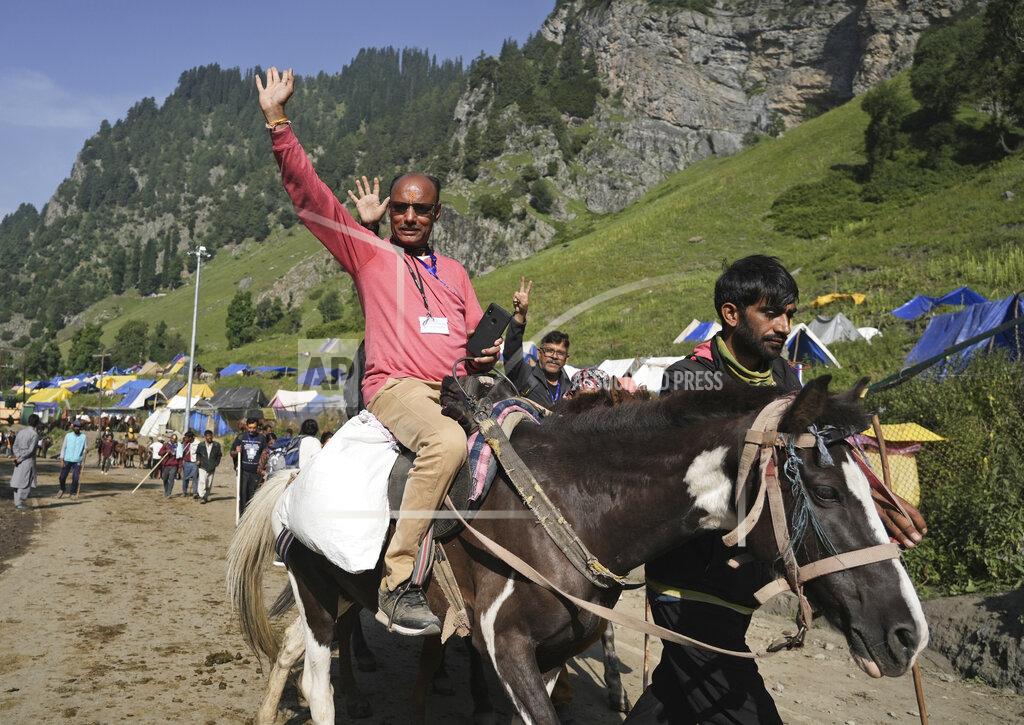 Uncredited A Hindu devotees raises his hand as he begins the Amarnath Yatra annual pilgrimage to to an icy Himalayan cave, in Chandanwari, Pahalgam, south of Srinagar, Indian-controlled Kashmir, Thursday, June 30, 2022. Officials say pilgrims face heightened threat of attacks from rebels fighting against Indian rule and have for the first time tagged devotees with wireless tracking system. They also have deployed drones for surveillance. (AP Photo)