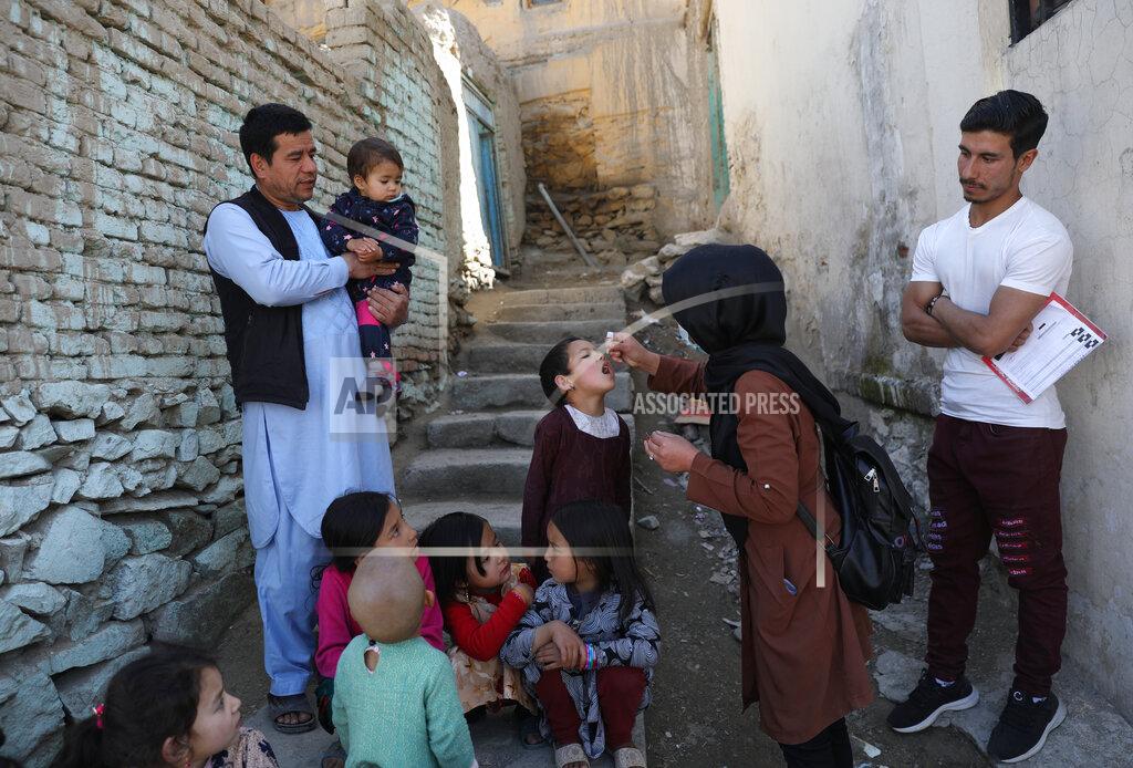 Rahmat Gul Shabana Maani, gives a polio vaccination to a child in the old part of Kabul, Afghanistan, Monday, March 29, 2021. Afghanistan is trying to inoculate millions of children against polio after pandemic lockdowns stalled the effort to eradicate the crippling disease. But the recent killing of three vaccinators points to the dangers facing the campaign as turmoil grows in the country. (AP Photo/Rahmat Gul)
