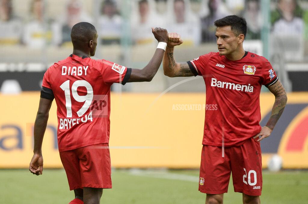 Ina Fassbender Leverkusen's French forward Moussa Diaby, left, and teammate Charles Mariano Aranguiz celebrate after the German Bundesliga soccer match between Borussia Moenchengladbach and Leverkusen, in Moenchengladbach, Germany, Saturday, May 23, 2020. (Ina Fassbender Pool Photo via AP)