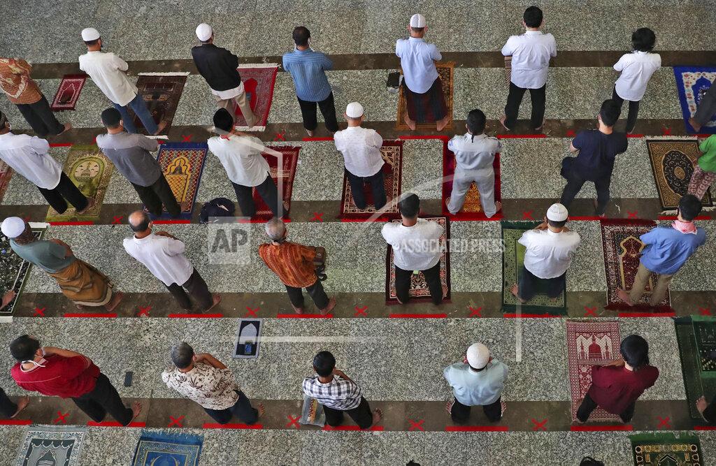 Achmad Ibrahim Muslim men pray on physical distancing markers as a precaution against the new coronavirus outbreak are seen on the floor during a Friday prayer at the At-Tin mosque in Jakarta, Indonesia, Friday, June 5, 2020. Muslims in Indonesia's capital held their first communal Friday prayers as mosques closed by the coronavirus outbreak for nine weeks reopened at half capacity. (AP Photo/Achmad Ibrahim)