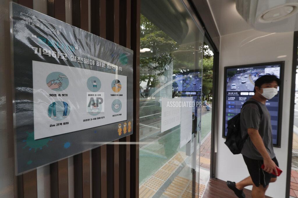 Ahn Young-Joon A poster on precautions against the coronavirus is displayed inside a bus shelter designed to block people with fever amid a spread of the coronavirus, at a bus stop in Seoul, South Korea, Friday, Aug. 14, 2020. The glass panels-covered bus stops at a Seoul district, are equipped with thermal cameras that screen people for fevers and also automatic doors that doesn’t let in any one with high temperatures. The sign reads "Prevention rules to remember and practice." (AP Photo/Ahn Young-joon)