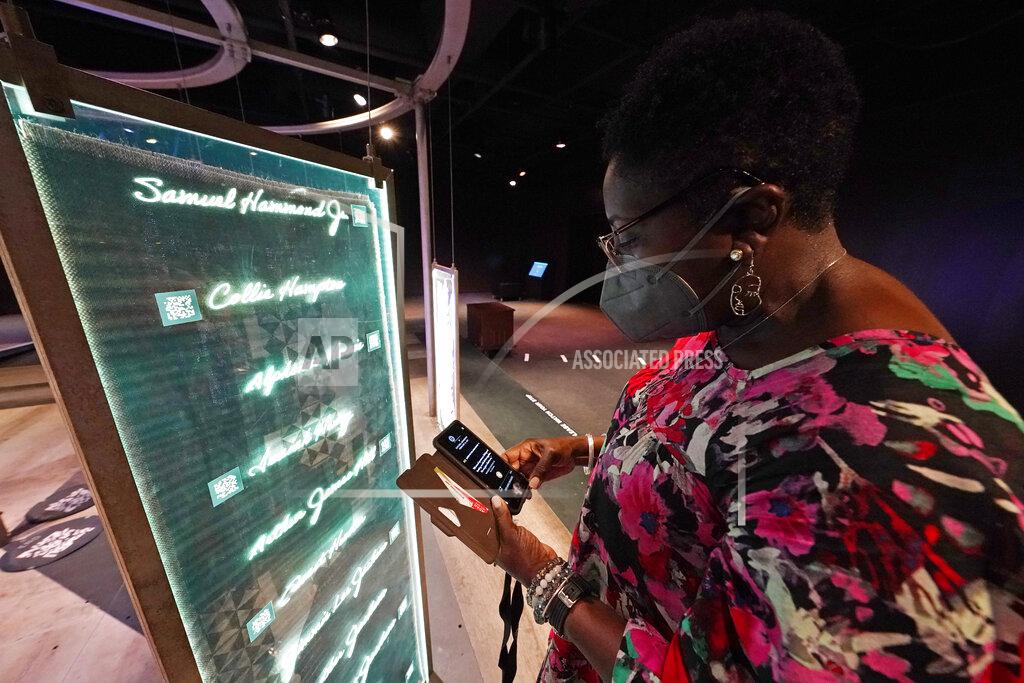 Rogelio V. Solis Pamela D.C. Junior, director of the Two Mississippi Museums in Jackson, searches for a specific cold case selection at the PBS Frontline's traveling augmented-reality exhibit, "Un(re)solved" in the museum's special exhibit room, Friday, Aug. 27, 2021. The exhibit was opened on Saturday, Aug. 28, to align with the commemoration of the death of Emmett Till, a Chicago teenager who was lynched in Mississippi in 1955. The multi-media platform examines the federal government's efforts to investigate more than 150 civil rights era cold cases on the Emmett Till Unsolved Civil Rights Crime Act. (AP Photo/Rogelio V. Solis)