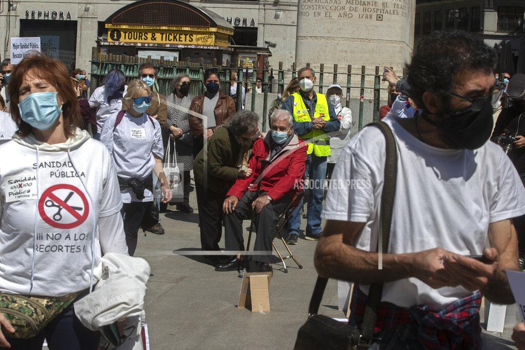 Paul White A man sits down during a protest in the central Puerta del Sol to protect the national health service during and after the pandemic, in Madrid, Spain, Saturday, April 17, 2021. Spanish Prime Minister Pedro Sanchez says he is "very hopeful" that Spain can come up with its own COVID-19 vaccine by the end of the year. (AP Photo/Paul White)