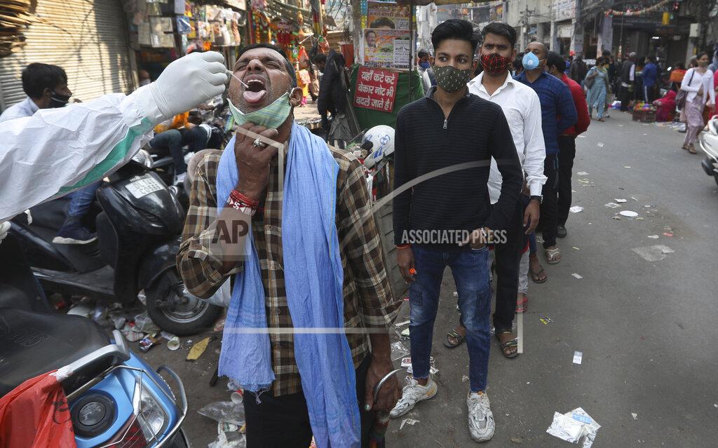 A health worker takes a sample to test for COVID-19 at a market area in New Delhi, India, Thursday, Nov. 19, 2020. India’s total number of coronavirus cases since the pandemic began has crossed 9 million. Nevertheless the country’s new daily cases have seen a steady decline for weeks now and the total number of cases represents 0.6% of India’s 1.3 billion population. (AP Photo/Manish Swarup)