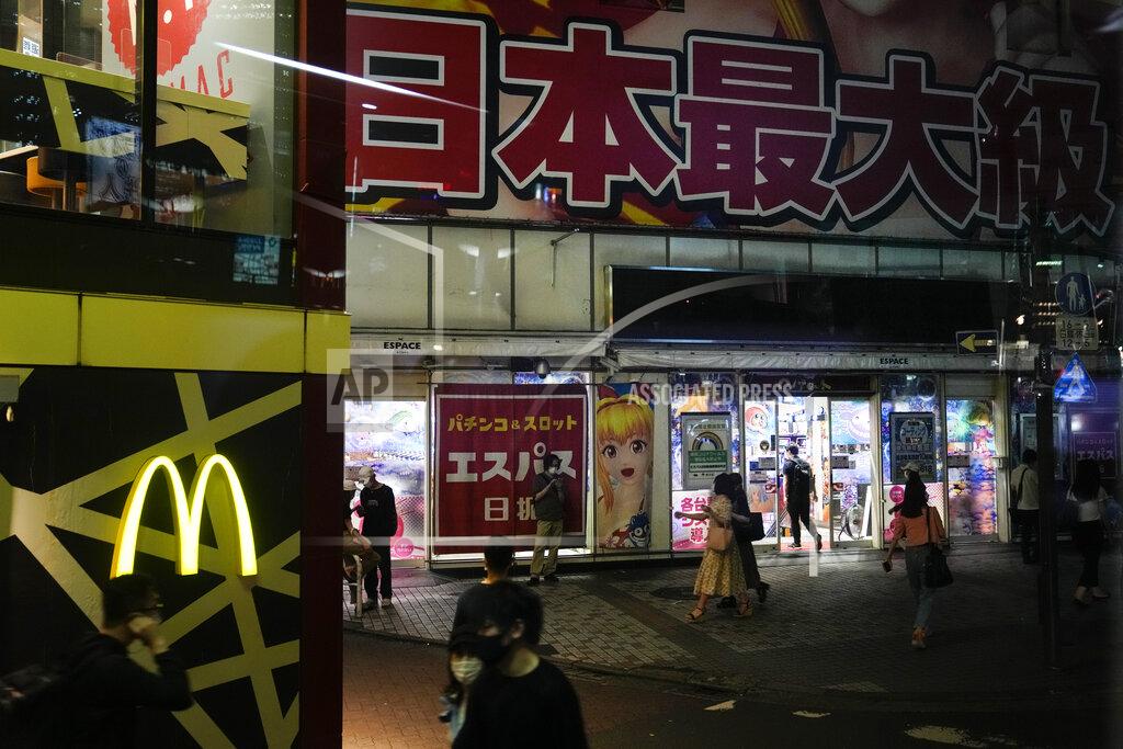 Jae C. Hong People walk near a pachinko parlor ahead of the 2020 Summer Olympics on Tuesday, July 13, 2021, in the Shinjuku district of Tokyo. (AP Photo/Jae C. Hong)