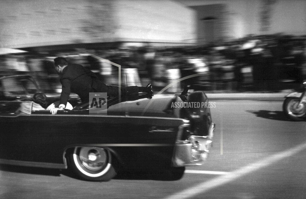 Justin Newman FILE - In this Nov. 22, 1963 file photo, the limousine carrying mortally wounded President John F. Kennedy races toward the hospital seconds after he was shot in Dallas. Secret Service agent Clinton Hill is riding on the back of the car, Nellie Connally, wife of Texas Gov. John Connally, bends over her wounded husband, and first lady Jacqueline Kennedy leans over the president. (AP Photo/Justin Newman, File)