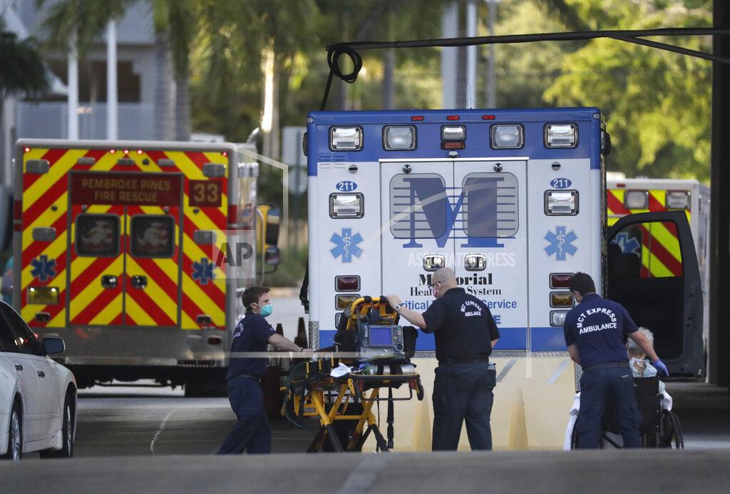 Crews return to their ambulances, Tuesday, May 12, 2020, at Memorial Regional Hospital in Hollywood, Fla. Emergency room visits have dropped by almost 50% across Florida since the coronavirus pandemic began as hospital officials on Tuesday warned that patients suffering from heart attacks and strokes are delaying or refusing care because they are afraid of going to the hospital. (AP Photo/Wilfredo Lee)