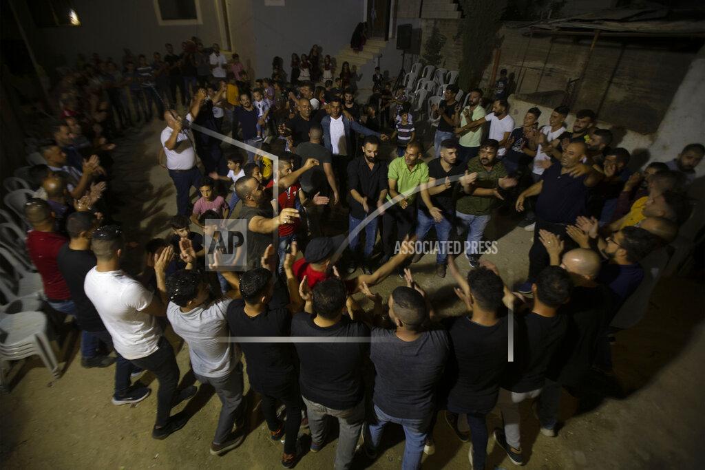 Majdi Mohammed Palestinians celebrate during a wedding party in Azmut near the West Bank city of Nablus, Thursday, Sept. 24, 2020. In a region where marriage is the cornerstone of society, couples are plowing ahead with weddings, despite the deadly risks. From the Palestinian territories to the United Arab Emirates, officials attribute a spike in coronavirus cases to traditional, large-scale weddings that flout public health restrictions.(AP Photo/Majdi Mohammed)