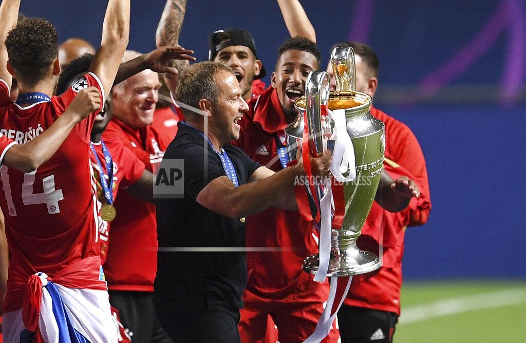 David Ramos Bayern's head coach Hansi Flick holds the trophy after winning the Champions League final soccer match between Paris Saint-Germain and Bayern Munich at the Luz stadium in Lisbon, Portugal, Sunday, Aug. 23, 2020. (David Ramos/Pool via AP)