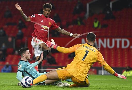 FILE - Manchester United's Marcus Rashford, top, scores his side's second goal during the English Premier League soccer match between Manchester United and Liverpool at the Old Trafford Stadium in Manchester, England, Thursday, May 13, 2021. New Jersey gambling regulators have fined two sports betting companies for mistakenly allowing 86 gamblers from New Jersey to place bets on whether Rashford would score a goal in the game after the game had already ended and Rashford had in fact scored. (Michael Regan/Pool Photo via AP, File)