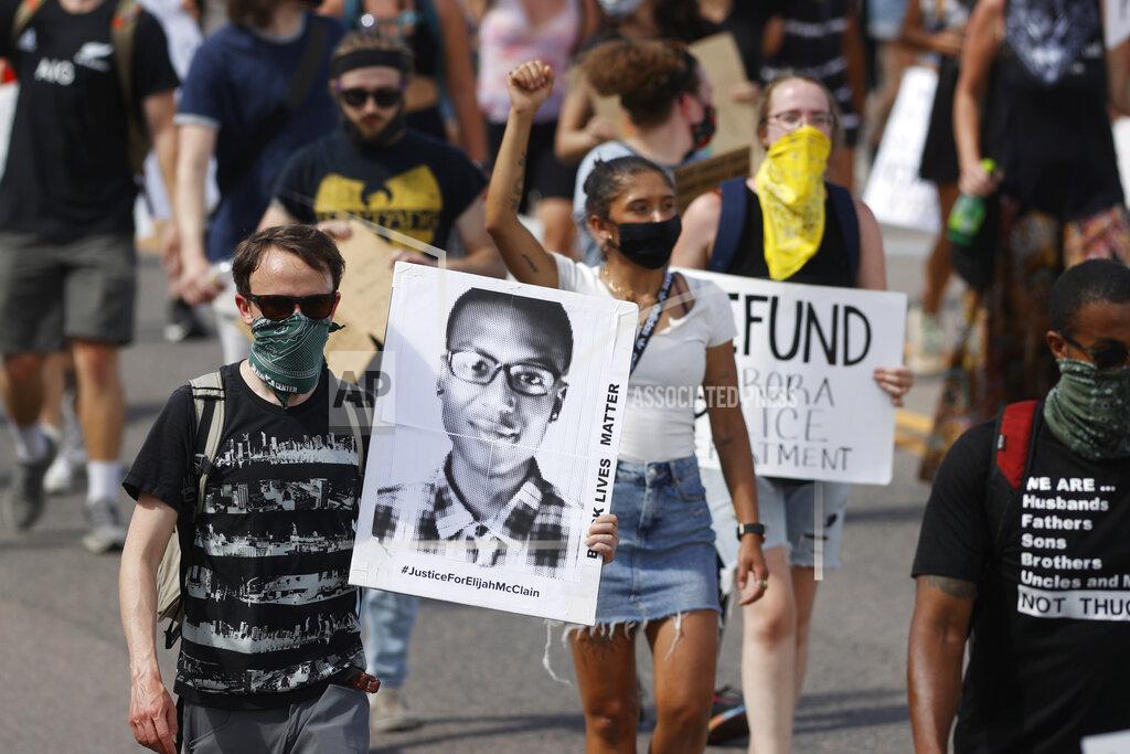 David Zalubowski FILE - In this June 27, 2020 file photo, demonstrators carry placards as they walk down Sable Boulevard during a rally and march over the death of Elijah McClain in Aurora, Colo. Colorado police reform advocates say the recent indictments of three suburban Denver police officers and two paramedics on manslaughter and other charges in the death of Elijah McClain could be a pivotal step toward meaningful accountability. (AP Photo/David Zalubowski, File)