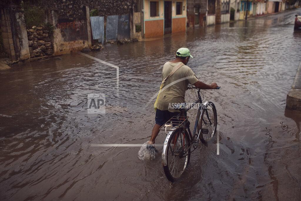 Andres Kudacki A man pushes his bicycle along a flooded street after the passing of Hurricane Delta in Tizimin, Mexico, Wednesday, Oct. 7, 2020. Delta made landfall Wednesday just south of the Mexican resort of Cancun as a Category 2 storm, downing trees and knocking out power to some resorts along the northeastern coast of the Yucatan Peninsula. (AP Photo/Andres Kudacki)