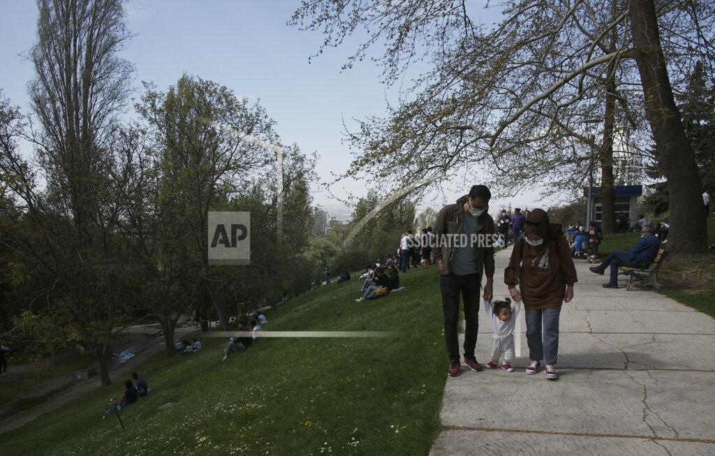 Burhan Ozbilici A couple walk a baby as people sit in a park in Ankara, Turkey, Thursday, April 29, 2021, just hours before the start of a three-week full lockdown. People stocked up on groceries, shoppers filled markets and many left cities for their hometowns or the southern coast as Turkey's strictest COVID-19 lockdown yet comes into effect later on Thursday. President Recep Tayyip Erdogan imposed a "full lockdown" from Thursday evening until May 17 amid soaring COVID-19 infections and deaths. Turkey now ranks among the world's worst-hit countries. (AP Photo/Burhan Ozbilici)