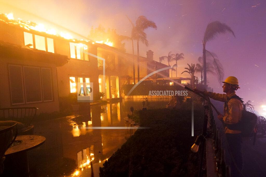 Marcio Jose Sanchez A firefighter works to put out a structure burning during a wildfire Wednesday, May 11, 2022, in Laguna Niguel, Calif. (AP Photo/Marcio Jose Sanchez)