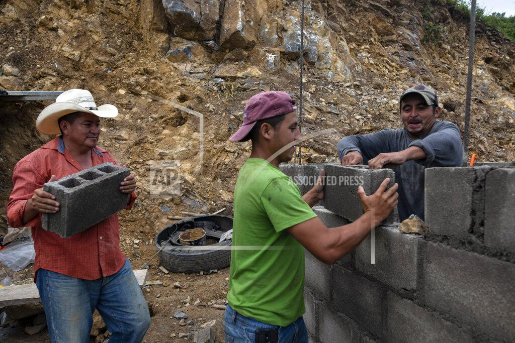 Rodrigo Abd Ivan Varela carries a cinder block as he helps day laborers lay brick for a new home for his parents, who were left homeless in November 2020 when their house was obliterated by a mudslide triggered by Hurricanes Eta and Iota, at the construction site in Mission San Francisco de Asis Honduras, Thursday, July 15, 2021. Each family must send one person to work on the construction of their home. They do not receive wages and if they don’t work, they must pay into a kitty about $6 a day (150 lempiras). (AP Photo/Rodrigo Abd)