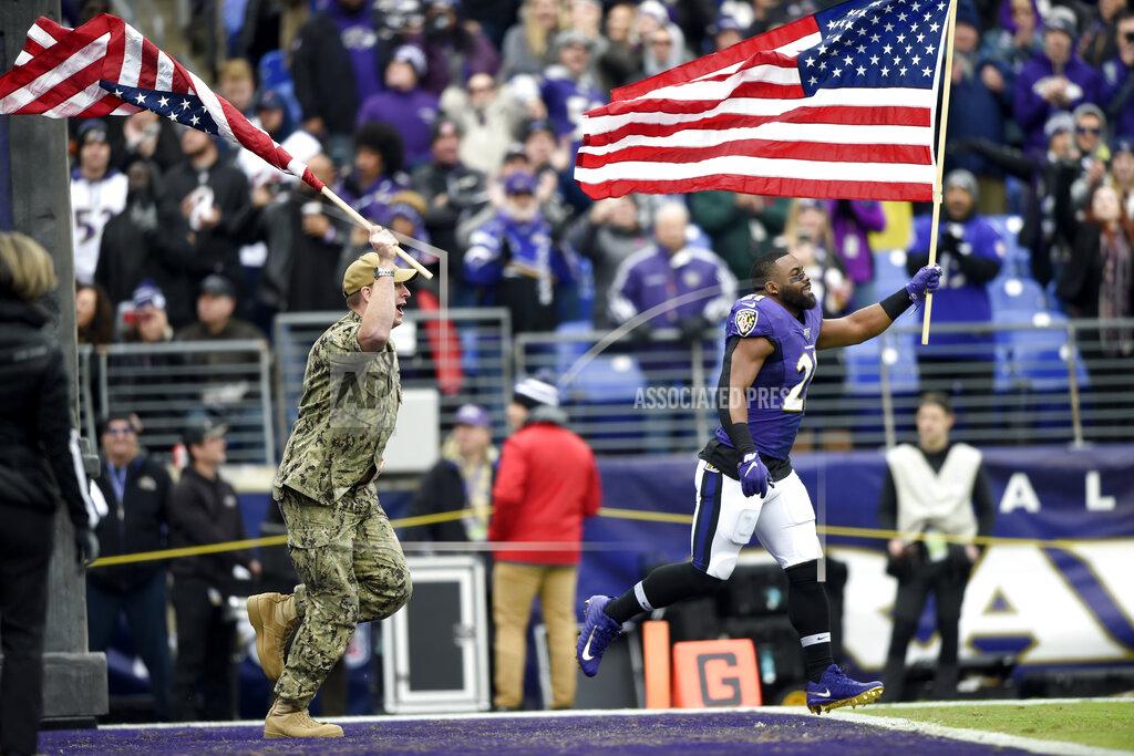 Gail Burton Baltimore Ravens running back Mark Ingram (21) and a U.S. service member run with flags as part of the team's Salute to Service prior to an NFL football game against the Houston Texans, Sunday, Nov. 17, 2019, in Baltimore. (AP Photo/Gail Burton)