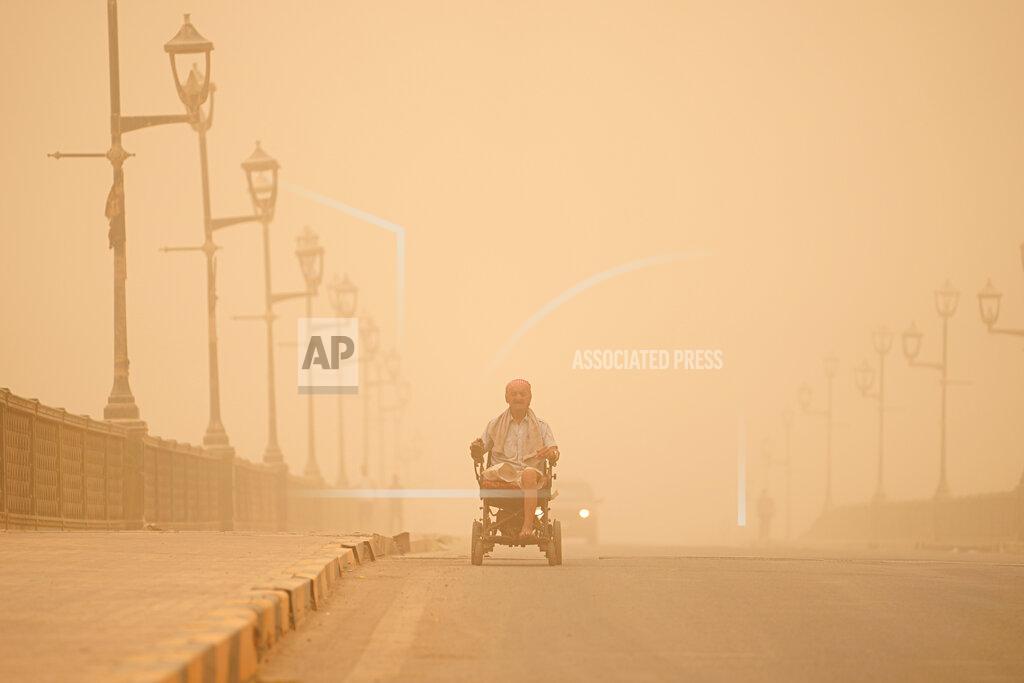 Hadi Mizban A man navigates his wheelchair on a street during a sand storm in Baghdad, Iraq, Monday, May 23, 2022. (AP Photo/Hadi Mizban)